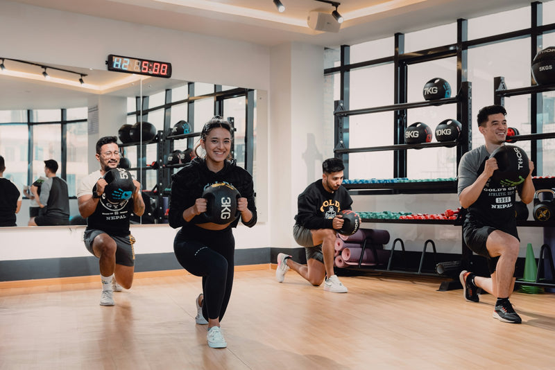 Group fitness class doing lunges in a bright studio